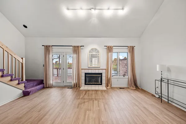 wooden floor fireplace and windows in an empty room