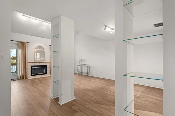 a view of a livingroom with wooden floor kitchen and an entryway