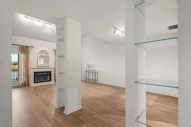 a view of a livingroom with wooden floor kitchen and an entryway