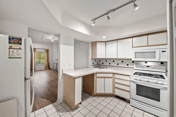 a kitchen with a stove sink and cabinets