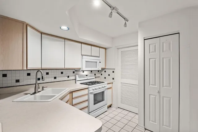 a kitchen with granite countertop a sink stove and cabinets
