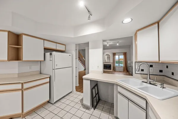 a kitchen with a sink a refrigerator and cabinets