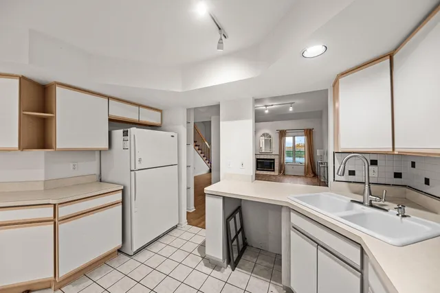 a kitchen with a sink a refrigerator and cabinets