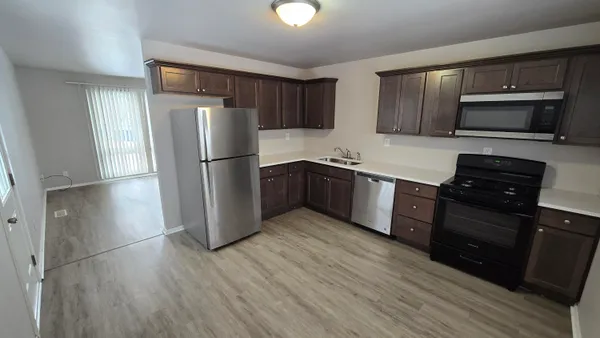 a kitchen with stainless steel appliances granite countertop a refrigerator a stove top oven a sink and dishwasher