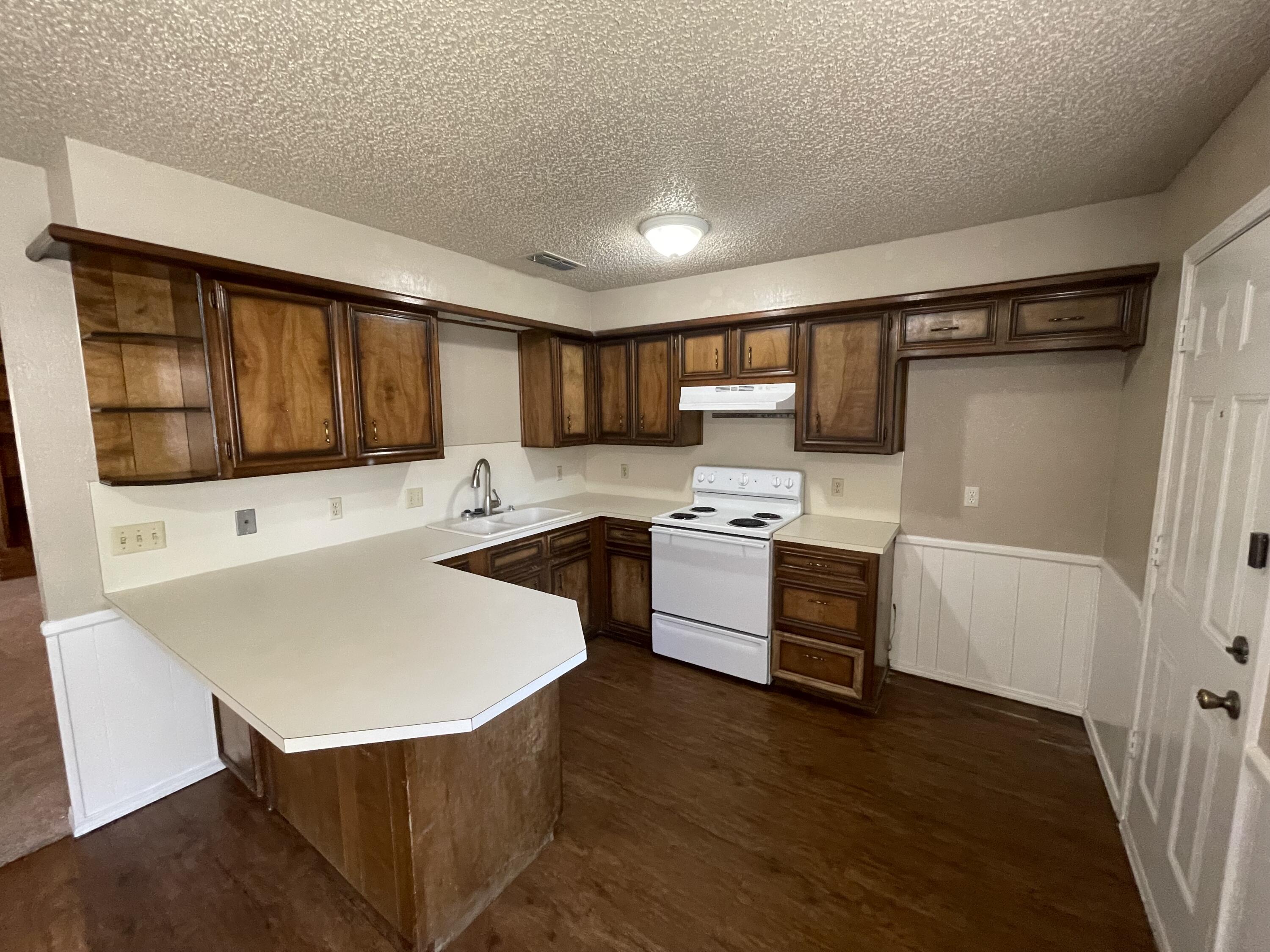 4413 75th Drive, Unit B Lubbock, TX 79424 - Photo 3 of 9 a kitchen with a sink a stove a microwave and cabinets