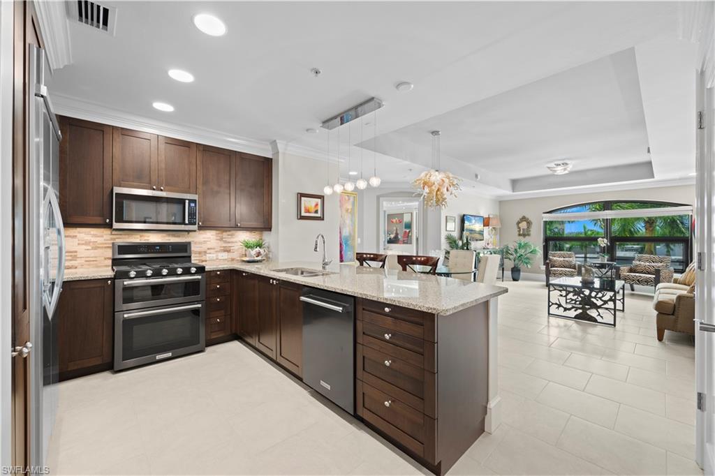 9115 Strada Place, Unit 5314 Naples, FL 34108 - Photo 5 of 44 a kitchen with stainless steel appliances granite countertop a sink stove and refrigerator