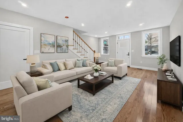 a living room with furniture flat screen tv and wooden floor