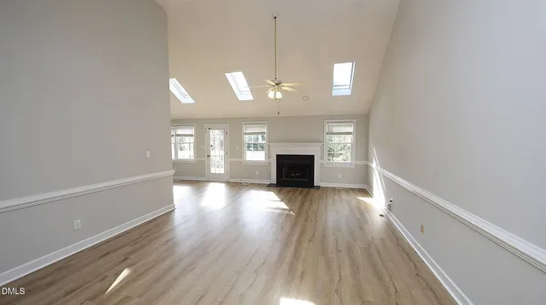 a view of empty room with wooden floor and fireplace