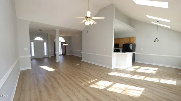a view of a hallway with wooden floor and a chandelier