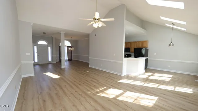 a view of a hallway with wooden floor and a chandelier