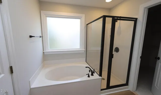 a bathroom with bathtub and shower
