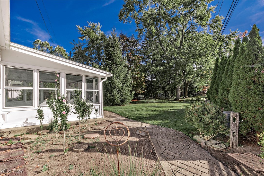 1691 Harwich Road Lyndhurst, OH 44124 - Photo 45 of 45 View of grassy yard featuring a sunroom, view of scattered trees, and a patio