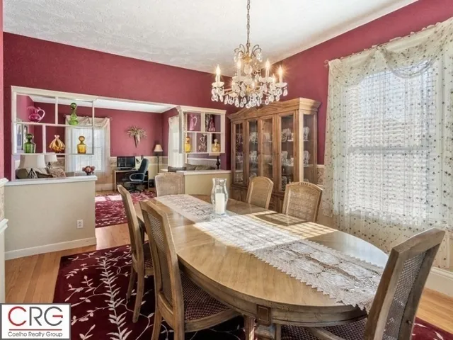 a view of a dining room with furniture a chandelier and window