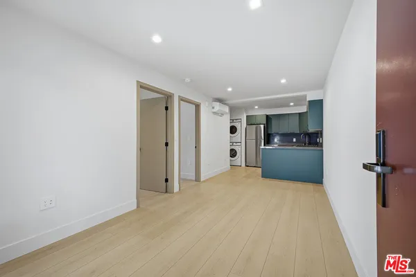 a view of livingroom with hardwood floor and a kitchen