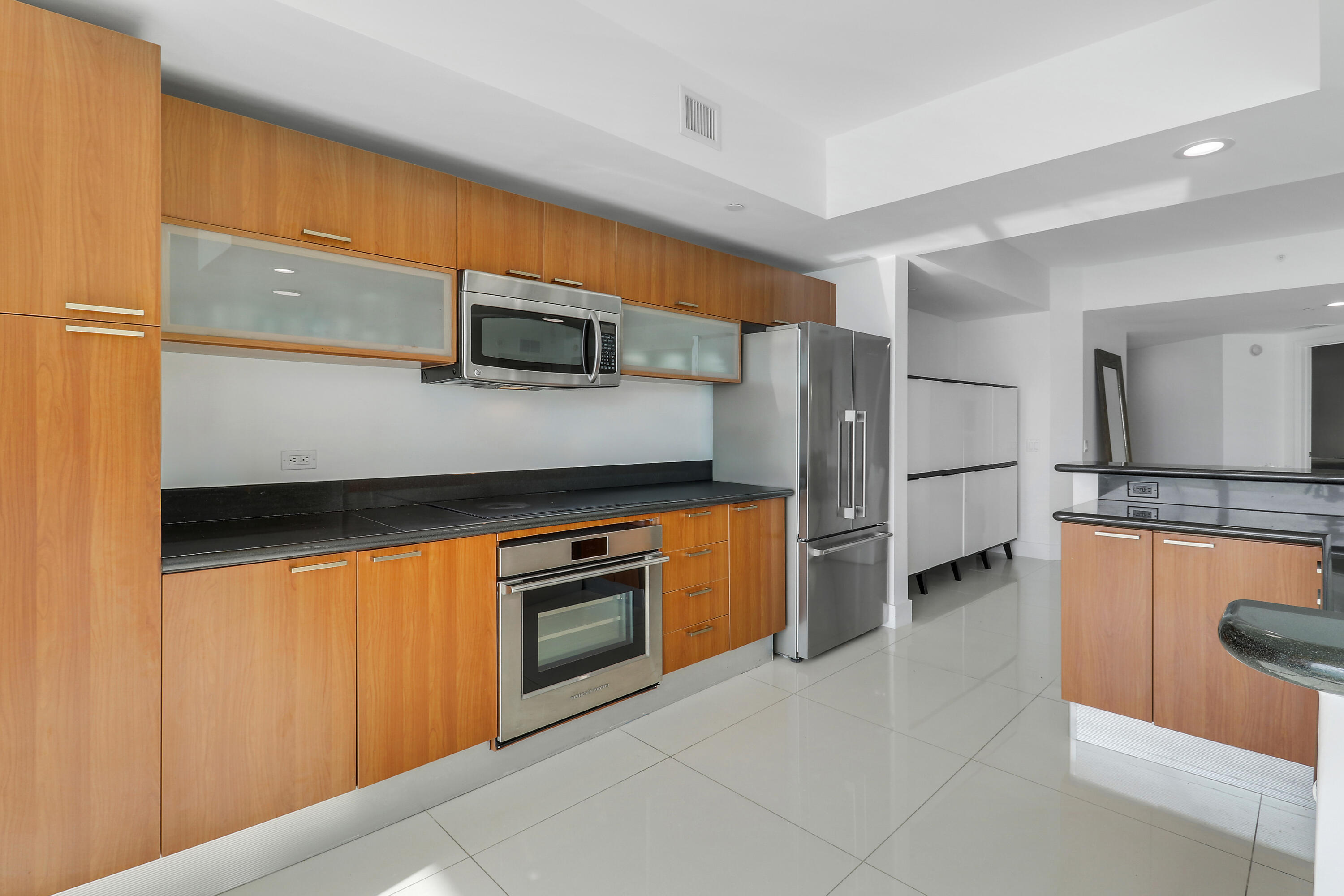 2640 Lake Shore Drive, Unit 307 Riviera Beach, FL 33404 - Photo 15 of 44 a kitchen with stainless steel appliances granite countertop a refrigerator and a stove top oven