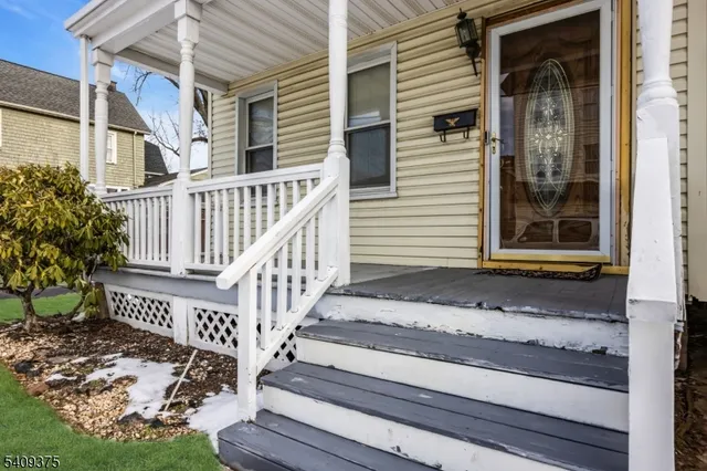 a view of a house with a small yard and wooden floor and fence