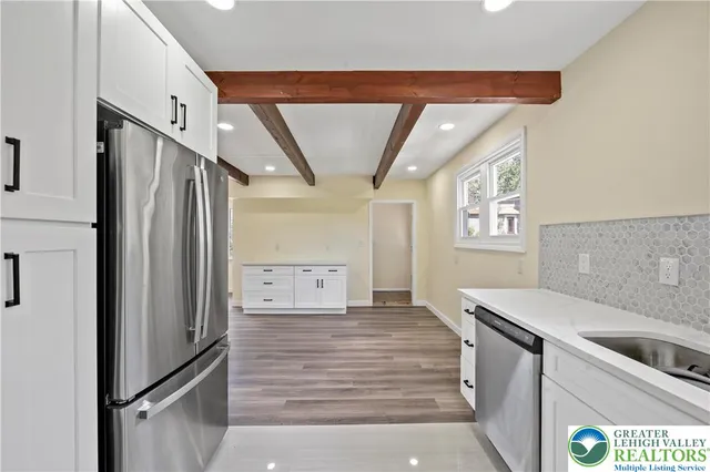 a kitchen with stainless steel appliances granite countertop a refrigerator and a sink