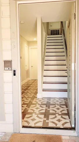 a view of a hallway with wooden floor and a living room