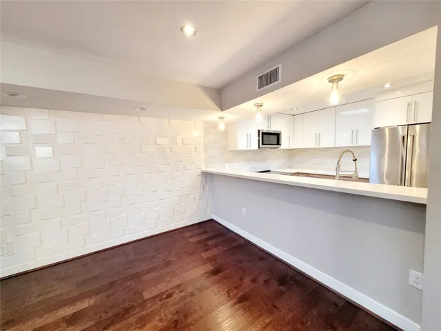 a kitchen with a sink cabinets stainless steel appliances and a window