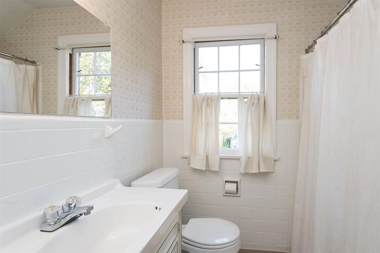1409 Hathaway Road Raleigh, NC 27608 - Photo 13 of 25 a bathroom with a sink a toilet and window