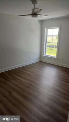 a view of a room with wooden floor and a window