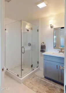 a bathroom with a shower a sink and a mirror