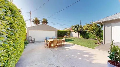 a view of a patio with table and chairs potted plants and a large tree