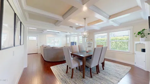 a dining room with furniture a chandelier and wooden floor