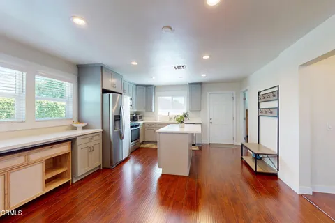 a kitchen with a sink appliances and wooden floor