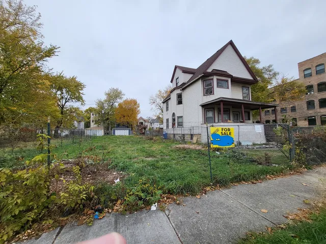 a front view of a house with a yard and potted plants