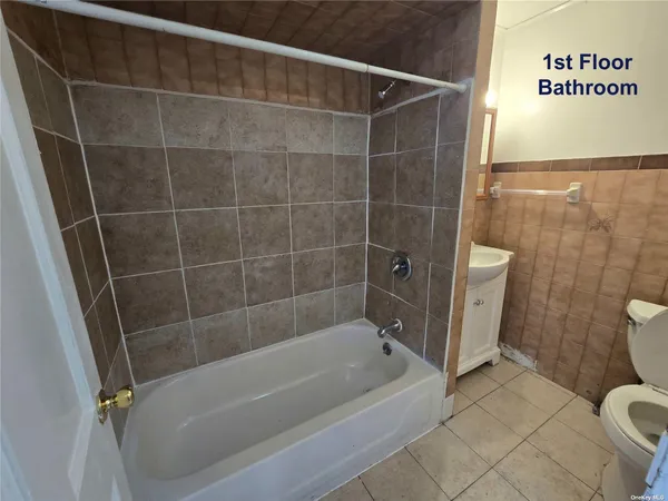 a bathroom with a tub a toilet and a shower