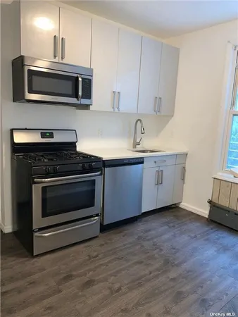 a kitchen with granite countertop a stove and a microwave
