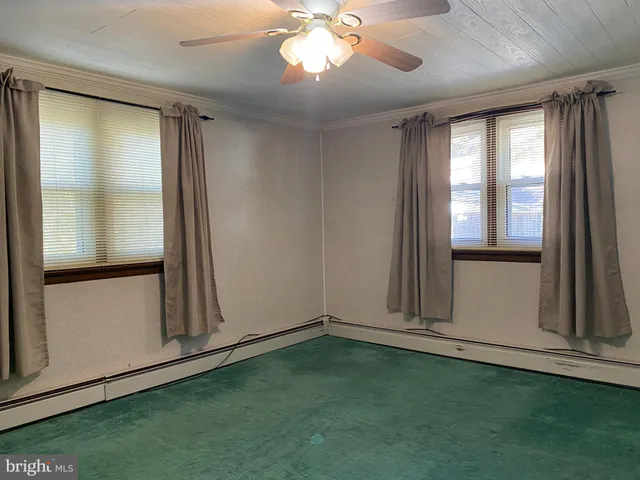 an empty room with closet and a chandelier fan