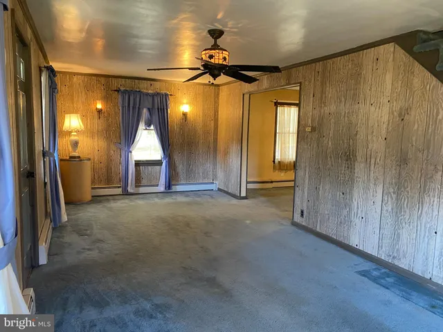 an empty room with a bathroom and a mirror