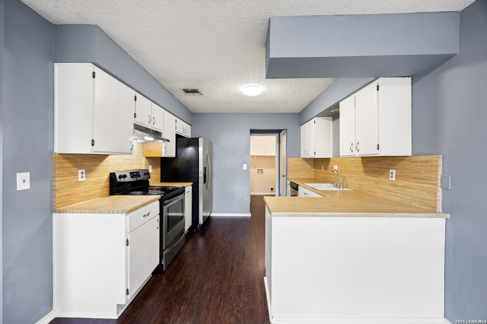 9334 Dover Ridge San Antonio, TX 78250 - Photo 13 of 42 a large kitchen with stainless steel appliances granite countertop a lot of counter space and wooden floor
