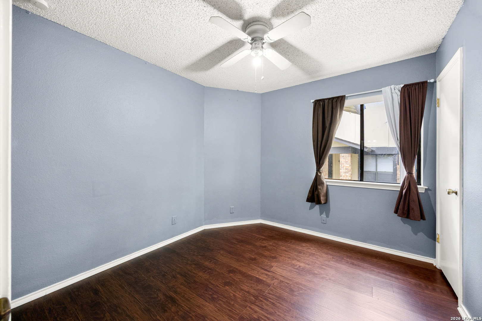 9334 Dover Ridge San Antonio, TX 78250 - Photo 18 of 42 an empty room with wooden floor fan and windows