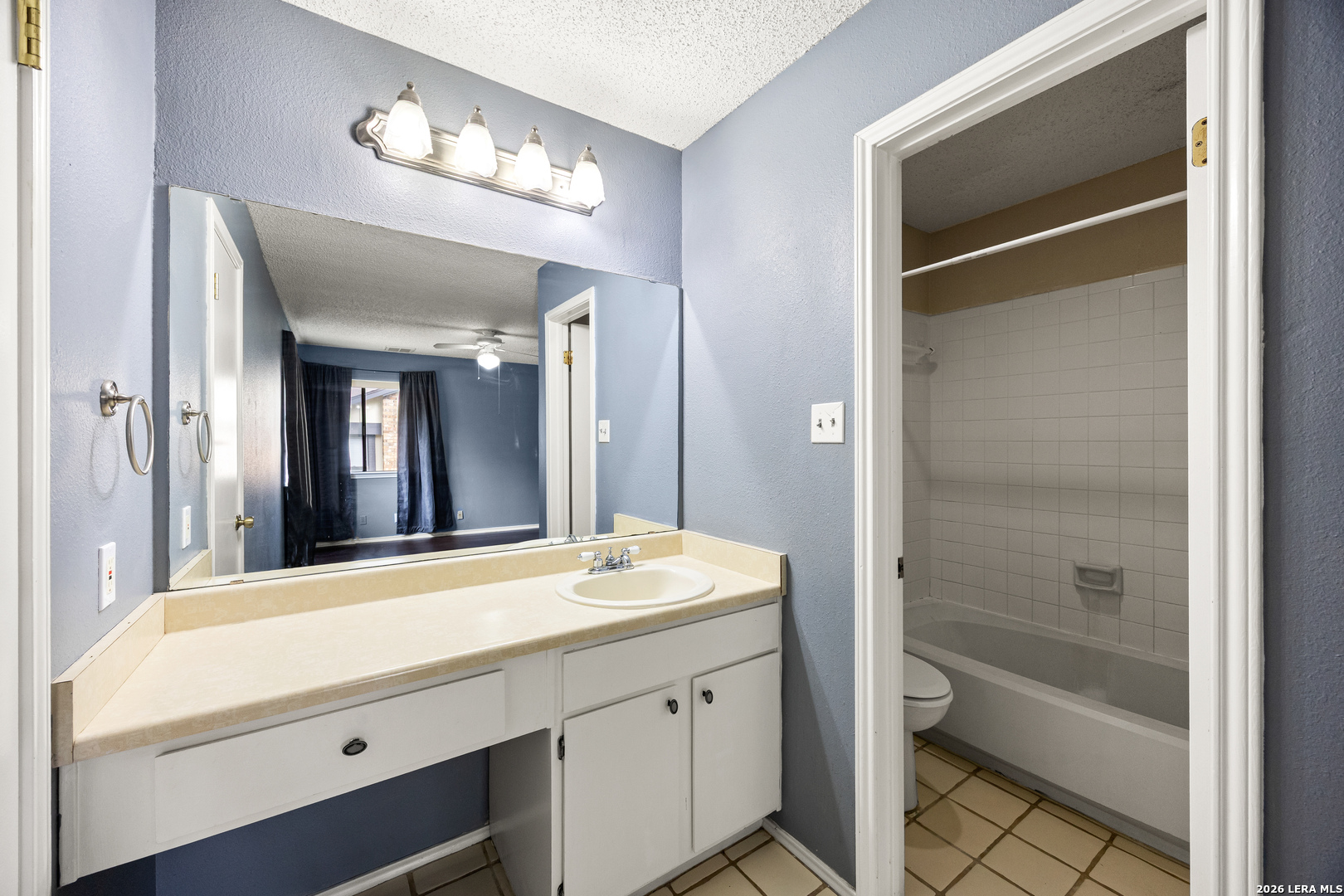 9334 Dover Ridge San Antonio, TX 78250 - Photo 23 of 42 a bathroom with a tub a sink and a large mirror