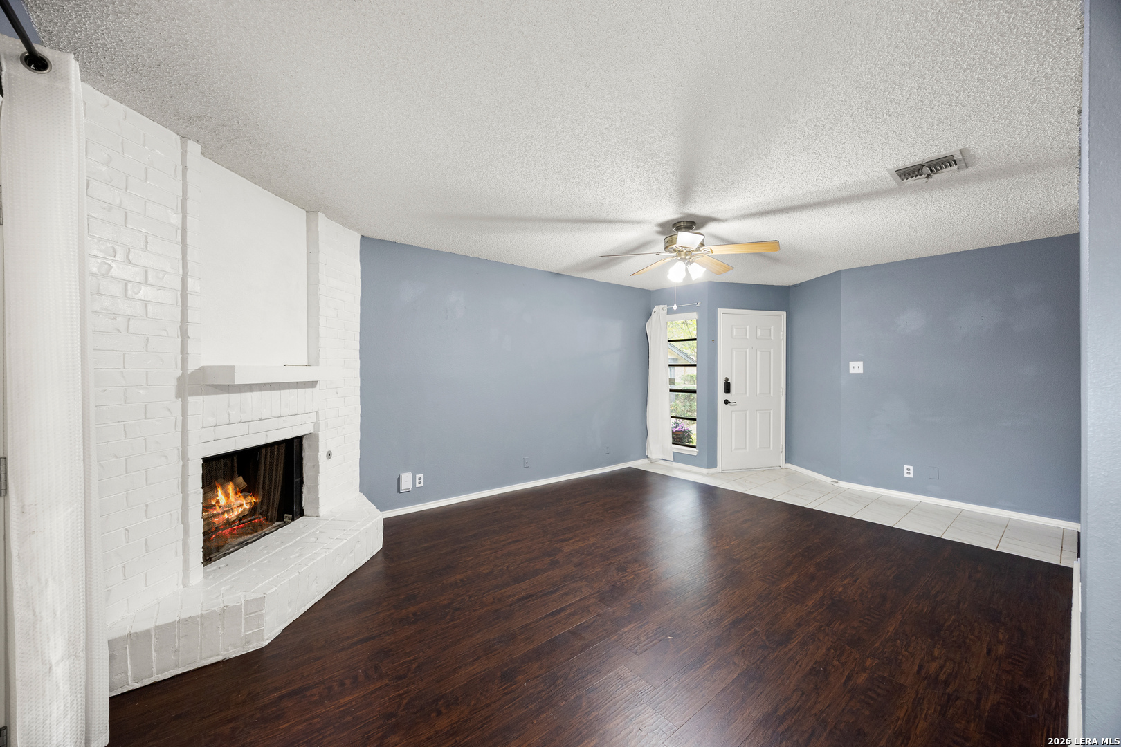 9334 Dover Ridge San Antonio, TX 78250 - Photo 10 of 42 a view of an empty room with wooden floor and a fireplace