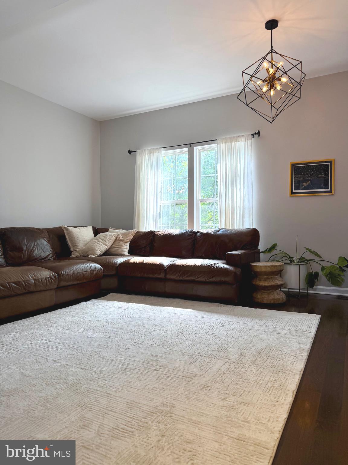 7108 Wheeling Way Gainesville, VA 20155 - Photo 20 of 45 a living room with a bed furniture and a chandelier