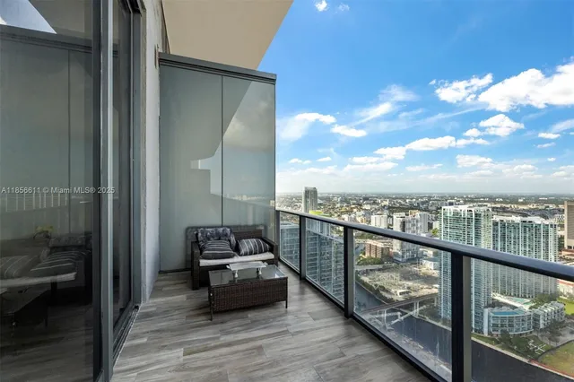 a view of a swimming pool with a lawn chairs and palm trees