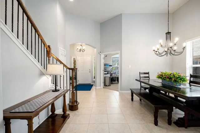 a room with chandelier fan and wooden furniture