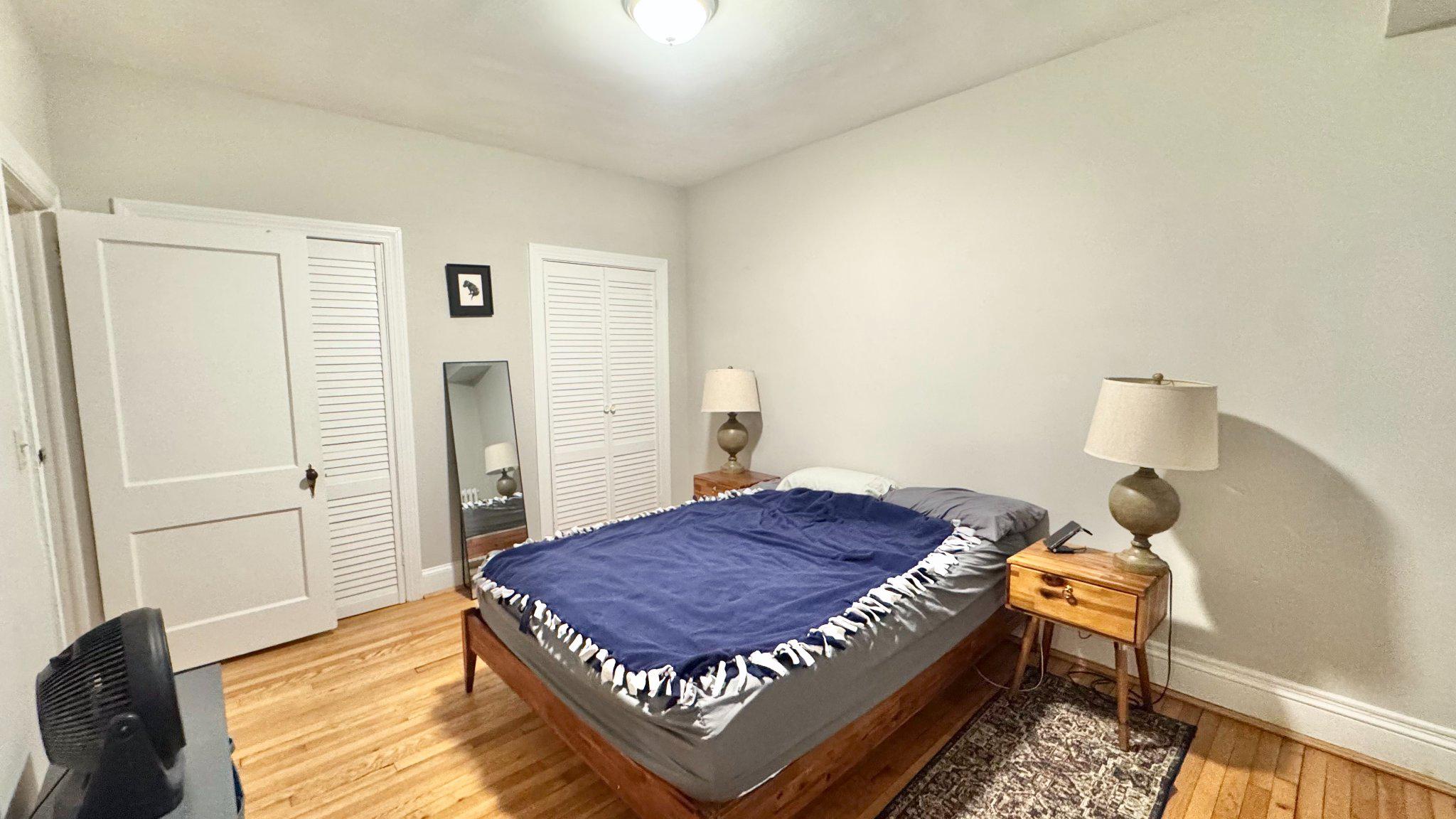 1954 Columbia Road Northwest, Unit 105 Washington, DC 20009 - Photo 8 of 12 a bedroom with a bed and wooden floor