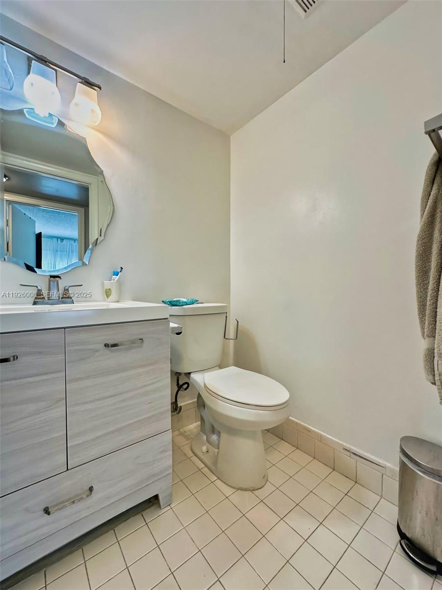 150 Southwest 134th Way, Unit 203R Pembroke Pines, FL 33027 - Photo 15 of 30 a bathroom with a toilet a sink and mirror
