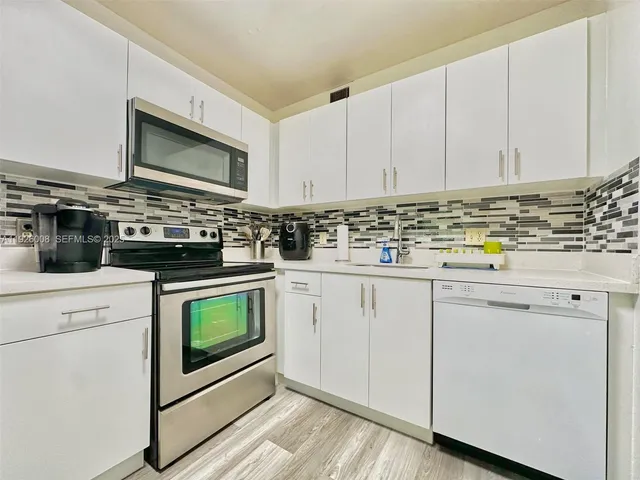 a kitchen with stainless steel appliances granite countertop a stove and a microwave