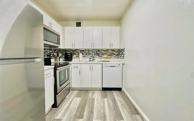a kitchen with a refrigerator and a stove