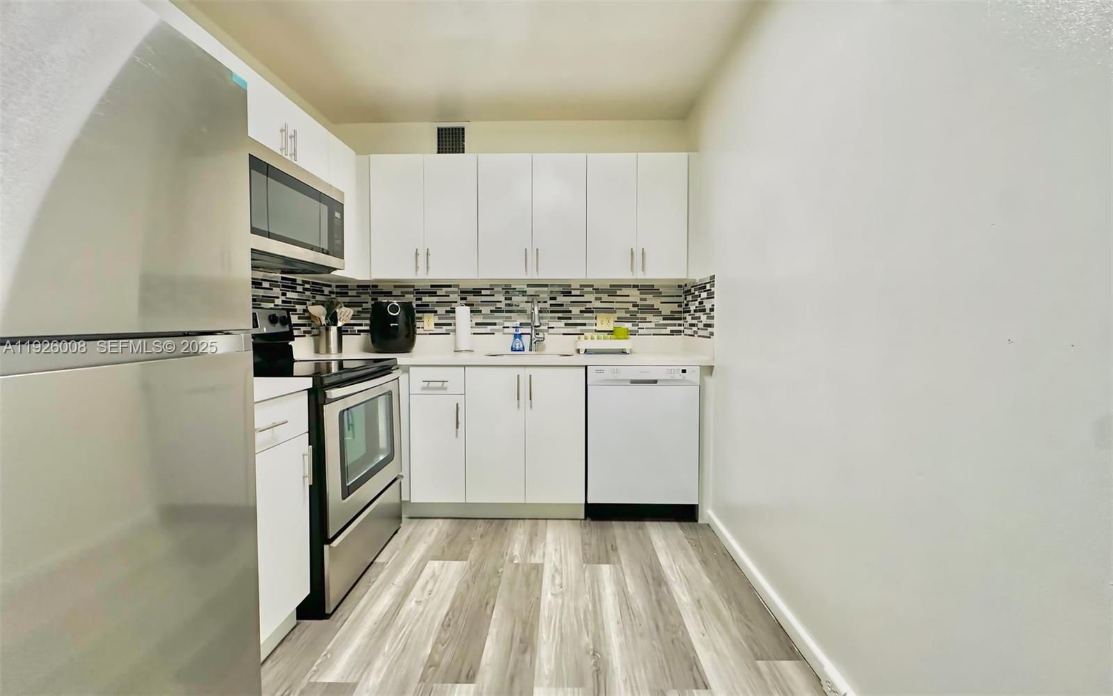 150 Southwest 134th Way, Unit 203R Pembroke Pines, FL 33027 - Photo 28 of 30 a kitchen with a refrigerator and a stove