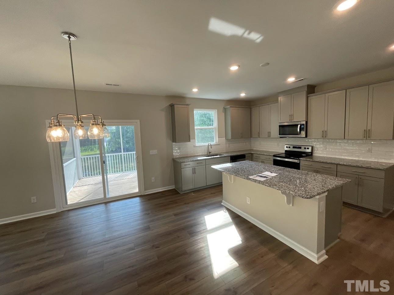 411 Rio Grande Lane Willow Spring, NC 27592 - Photo 3 of 29 a kitchen with stainless steel appliances granite countertop a sink a stove and a wooden floors