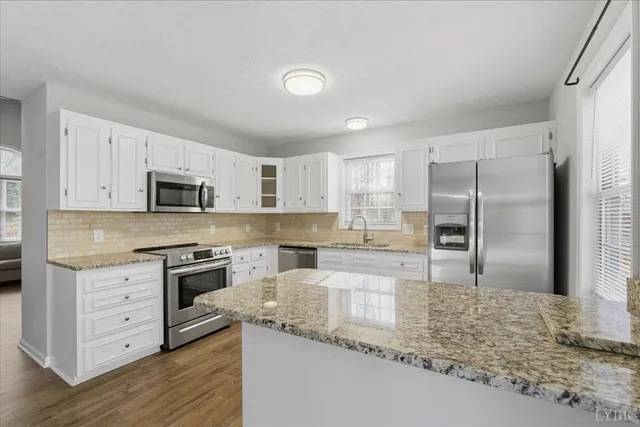 a kitchen with stainless steel appliances granite countertop a refrigerator sink and stove