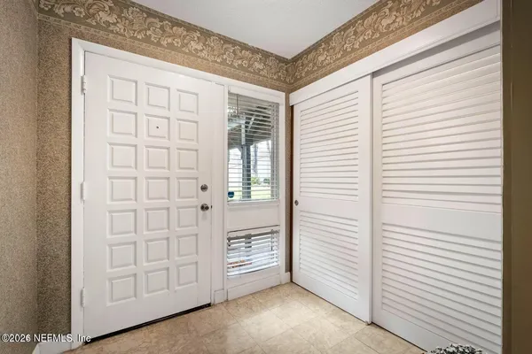 a view of an empty room with cabinet and a window