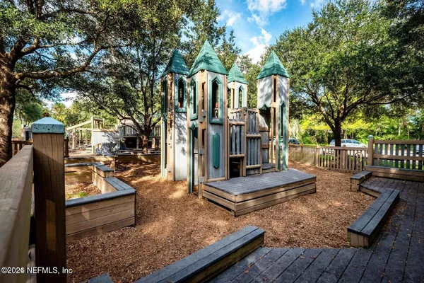 a view of house with yard outdoor seating and covered with trees